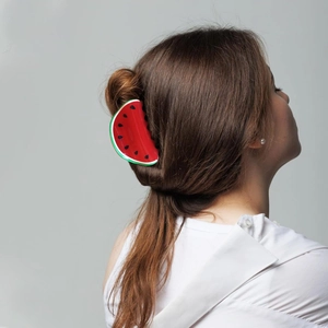 Detail of watermelon hair claw clip holding a half-up hairstyle on a model's back