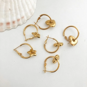 Gold stainless steel hoop earrings set with heart and star charms on white background