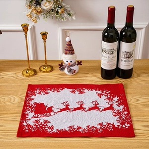 Close-up of red and white knitted Christmas placemat with Santa and reindeer pattern