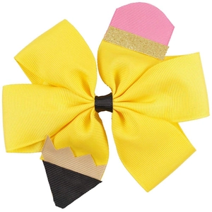 Detail of creative pencil-shaped bow hair clip with yellow ribbed ribbon and gold glitter