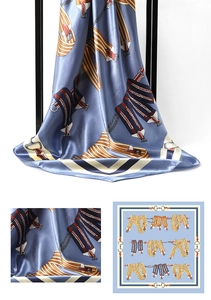 Detail of light blue satin silk scarf featuring classic horse harness and buckle prints