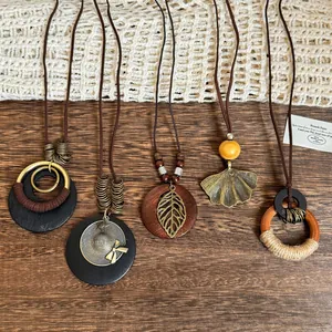 Detail of five bohemian long necklaces with wood beads and vintage bronze leaf pendants
