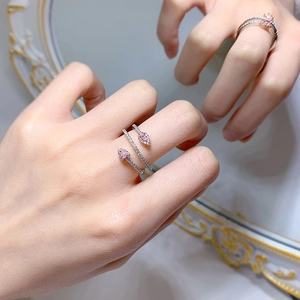 Detail of 925 silver snake ring with pink pear-shaped stones worn on finger