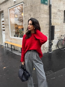 Women's vintage oversized red cable knit sweater paired with stylish grey trousers