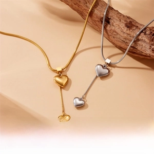 Detailed macro of gold heart pendant with fine snake chain on wooden branch