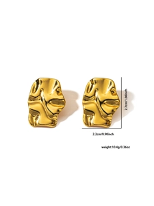 Vue détaillée de boucles d'oreilles dorées irrégulières avec texture ondulée et taille