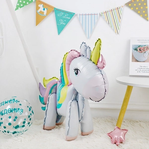 Standing 3D rainbow unicorn foil balloon on a white plush rug for birthday party decor