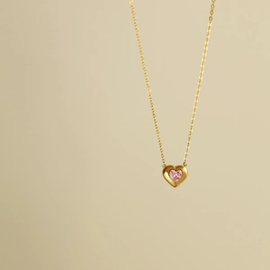 Detailed view of 18K gold plated heart pendant featuring a delicate pink gemstone
