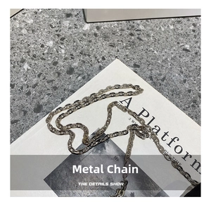 Close-up of bright silver metal chain strap with polished circular ring link design