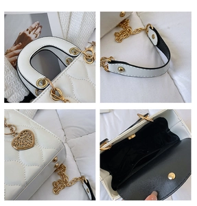 Detailed close-up showing gold heart charm and quilted white leather bag texture