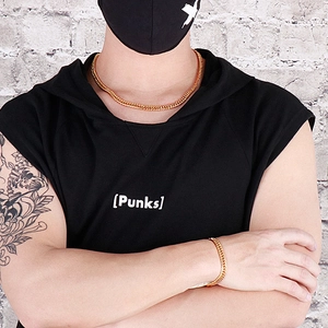 Mannequin portant un collier et un bracelet en maille gourmette dorée avec un t-shirt noir