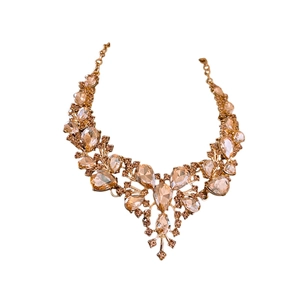 Parure collier dorée avec cristaux champagne en goutte sur fond blanc pur