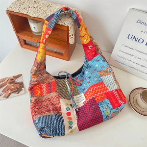 Detailed patchwork corduroy tote bag featuring ethnic patterns and woven brand label