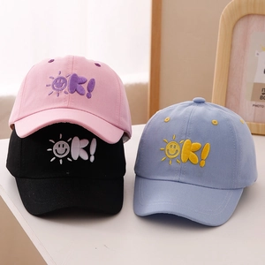 Detailed view of the 'OK!' sun embroidery on colorful cotton baseball caps for kids