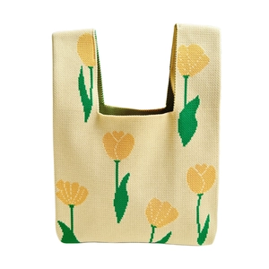 Minimalist beige knitted tote bag featuring yellow tulip floral patterns on white background