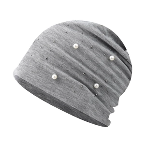 Detail of grey knitted winter hat featuring white faux pearls and silver rhinestones