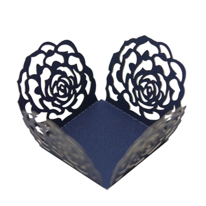 Détail de la dentelle découpée au laser rose sur boîte à bonbons de mariage bleu foncé