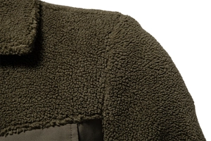 Dettaglio delle cuciture e della texture in pile sherpa verde oliva sulla spalla