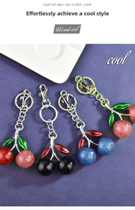 Close-up of cherry keychain charms with glitter texture and metallic lobster clasps