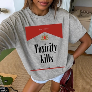 Λεπτομέρεια γκρι βαμβακερού T-shirt με κόκκινο γραφικό και κείμενο Toxicity kills