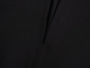 Detailed macro view of high-quality zipper closure on black crepe fabric dress