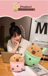 Close-up of cute pink and green capybara plushies in bubble tea cup costumes on desk