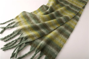 Macro shot of green and yellow striped cashmere-like scarf showing texture and soft fringes