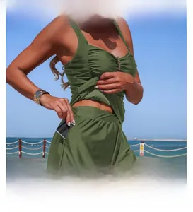 Detail of army green tankini set featuring side pockets and ruched bodice on a beach