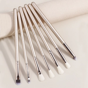 Kit de 7 pinceaux à maquillage yeux champagne doré avec poils dégradés sur fond texturé