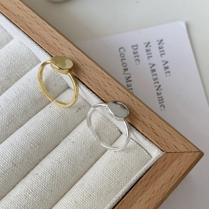 Close-up of minimalist gold and silver S925 sterling silver rings with smooth flat top surface