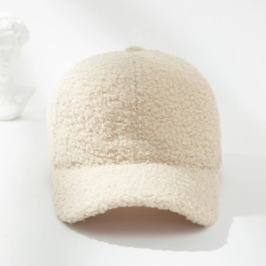 Detailed texture of creamy white teddy fleece fabric on a minimalist baseball cap