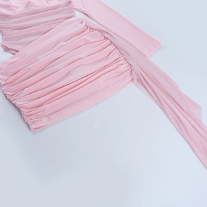 Detalle del vestido ajustado rosa con fruncido en cintura y detalles de cintas de malla