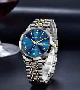 Macro view of blue sunray dial and gold-silver stainless steel link band for men