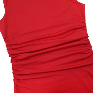 Detailed macro view showing red ruched fabric texture and elastic stitching on dress
