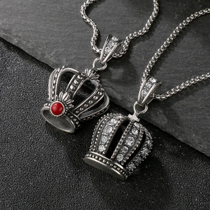 Detailed macro view of vintage crown pendants with red gem and clear zircon inlay