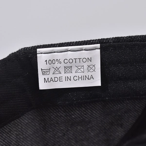 Detail of 100% cotton wash label stitched on a black washed denim outdoor cap