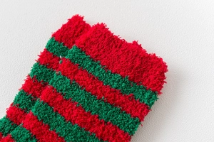 Detail of red and green striped coral fleece Christmas socks with soft fuzzy texture