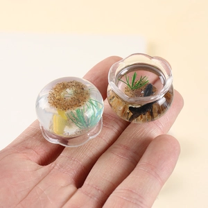 Mini pendentifs d'aquarium en résine avec carpes koi et plantes, tenus en main