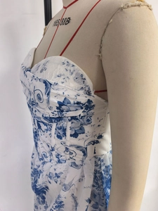 Close-up of white tube maxi dress with blue floral print and white lace corset detail