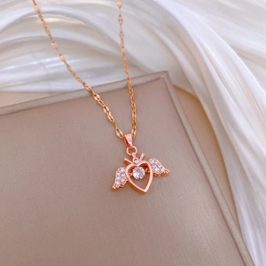 Macro detail of rose gold heart wing pendant with dancing stone and shimmering crystal inlay