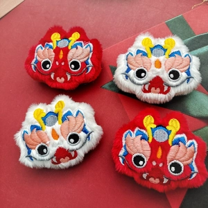 Detailed view of four plush dragon dance lion accessories with intricate colorful embroidery