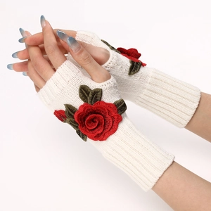 Close-up of white knitted fingerless gloves featuring elegant red rose embroidery details