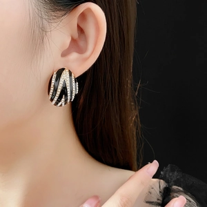 Vintage gold-edged oval earrings with black glaze and sparkling rhinestone wave pattern