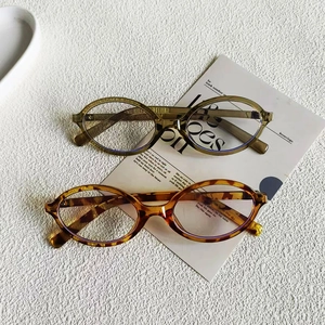 Detail of vintage oval frames in olive green and tortoiseshell on a textured background