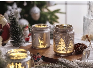Detail of frosted glass Christmas jar with warm LED light and reindeer silhouette scene