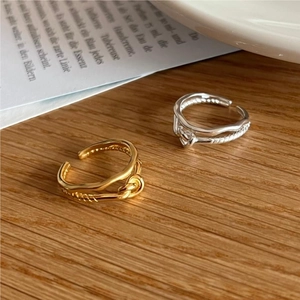 Minimalist 925 silver twist knot open rings in gold and silver finish on wooden surface