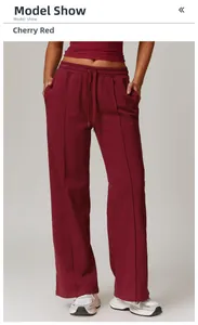 Detail view of cherry red wide-leg sweatpants with drawstring waist and stitched pleat