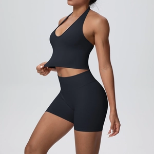 Detail of black halter yoga bra and high waist ribbed shorts set on a fit model