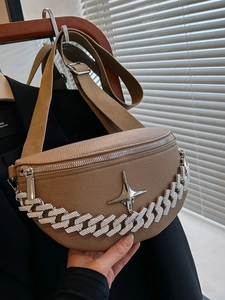Close-up of brown lychee-patterned bag with silver chunky chain and star metal tag
