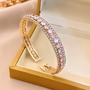 Gros plan du bracelet jonc en or rose avec zircons roses et blancs dans un écrin à bijoux